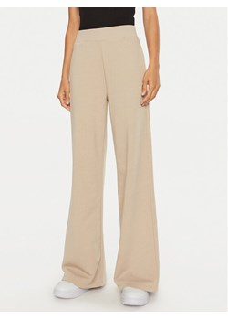 Calvin Klein Jeans Spodnie dresowe J20J222597 Beżowy Relaxed Fit ze sklepu MODIVO w kategorii Spodnie damskie - zdjęcie 181167623