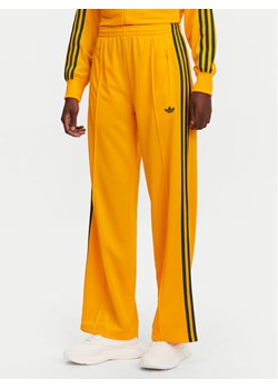 adidas Spodnie dresowe adicolor Classic Firebird JP2316 Żółty Loose Fit ze sklepu MODIVO w kategorii Spodnie damskie - zdjęcie 181169071