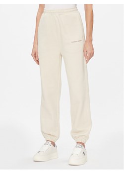 Tommy Jeans Spodnie dresowe Classics DW0DW17309 Écru Relaxed Fit ze sklepu MODIVO w kategorii Spodnie damskie - zdjęcie 181173441