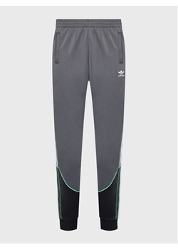 adidas Spodnie dresowe Tricot Sst HI3006 Szary Regular Fit ze sklepu MODIVO w kategorii Spodnie męskie - zdjęcie 181179212