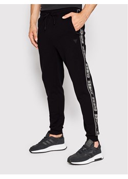 Guess Spodnie dresowe Z2YB19 K6ZS1 Czarny Regular Fit ze sklepu MODIVO w kategorii Spodnie męskie - zdjęcie 181181304