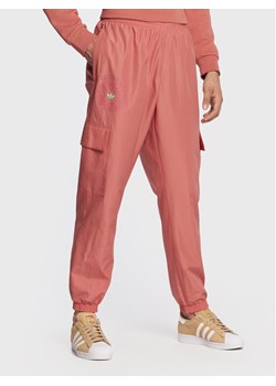 adidas Spodnie dresowe Ozworld HL9254 Pomarańczowy Regular Fit ze sklepu MODIVO w kategorii Spodnie męskie - zdjęcie 181182273