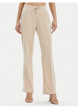 Juicy Couture Spodnie dresowe Tina JCAPW045 Beżowy Regular Fit ze sklepu MODIVO w kategorii Spodnie damskie - zdjęcie 181199770