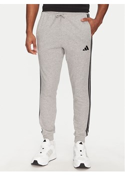 adidas Spodnie dresowe Essential 3-Stripes JE6346 Szary Regular Fit ze sklepu MODIVO w kategorii Spodnie męskie - zdjęcie 181205402