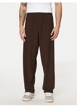 adidas Spodnie dresowe Monogram Track JP4428 Brązowy Regular Fit ze sklepu MODIVO w kategorii Spodnie męskie - zdjęcie 182599991