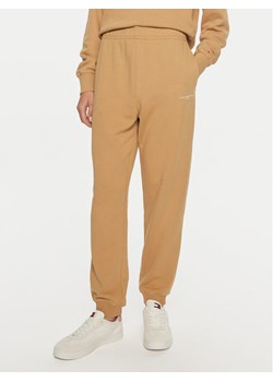 Tommy Hilfiger Spodnie dresowe WW0WW42883 Beżowy Regular Fit ze sklepu MODIVO w kategorii Spodnie damskie - zdjęcie 182600130