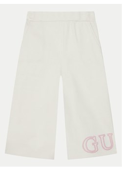 Guess Spodnie dresowe K5RQ11 KA6R4 Écru Regular Fit ze sklepu MODIVO w kategorii Spodnie dziewczęce - zdjęcie 182609751