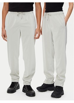 Rains Spodnie przeciwdeszczowe Unisex 18560 Beżowy Regular Fit ze sklepu MODIVO w kategorii Kurtki damskie - zdjęcie 182613100