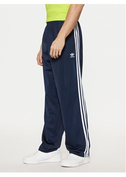 adidas Spodnie dresowe adicolor Classics Firebird IM9471 Granatowy Regular Fit ze sklepu MODIVO w kategorii Spodnie męskie - zdjęcie 182626890