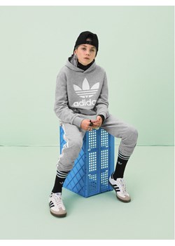 adidas Spodnie dresowe Trefoil 3-Stripes GD2705 Szary Regular Fit ze sklepu MODIVO w kategorii Spodnie chłopięce - zdjęcie 182629102