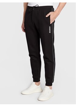 Guess Spodnie dresowe Mickey Z2YB09 KB3P2 Czarny Regular Fit ze sklepu MODIVO w kategorii Spodnie męskie - zdjęcie 182634932