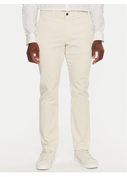 Tommy Hilfiger Spodnie materiałowe MW0MW32932 Écru Regular Fit ze sklepu MODIVO w kategorii Spodnie męskie - zdjęcie 182637302