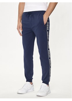 Guess Spodnie dresowe Z2YB19 K6ZS1 Granatowy Regular Fit ze sklepu MODIVO w kategorii Spodnie męskie - zdjęcie 182638200