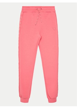 Guess Spodnie dresowe J2YQ24 FL03S Różowy Regular Fit ze sklepu MODIVO w kategorii Spodnie dziewczęce - zdjęcie 182639953