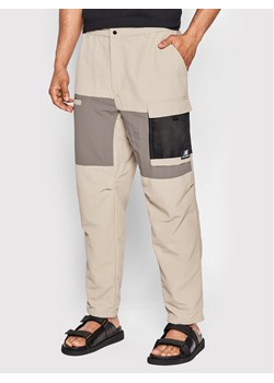 New Balance Spodnie materiałowe MP21502 Beżowy Relaxed Fit ze sklepu MODIVO w kategorii Spodnie męskie - zdjęcie 182646322