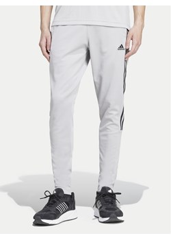 adidas Spodnie dresowe Tiro IY4288 Szary Regular Fit ze sklepu MODIVO w kategorii Spodnie męskie - zdjęcie 182654472