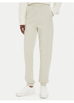 Calvin Klein Jeans Spodnie dresowe J20J224443 Beżowy Regular Fit ze sklepu MODIVO w kategorii Spodnie damskie - zdjęcie 182669871