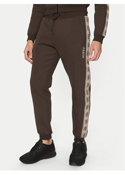 Guess Spodnie dresowe Z2YB09 KB3P2 Brązowy Regular Fit ze sklepu MODIVO w kategorii Spodnie męskie - zdjęcie 182674740