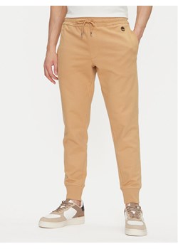 Timberland Spodnie dresowe TB0A5V5Q Beżowy Regular Fit ze sklepu MODIVO w kategorii Spodnie męskie - zdjęcie 182679373