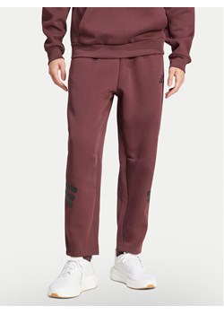 adidas Spodnie dresowe Future Icons 3-Stripes JD4888 Bordowy Loose Fit ze sklepu MODIVO w kategorii Spodnie męskie - zdjęcie 182682631