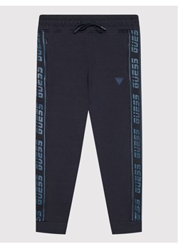 Guess Spodnie dresowe L2RQ15 K6ZS1 Granatowy Regular Fit ze sklepu MODIVO w kategorii Spodnie chłopięce - zdjęcie 182683664