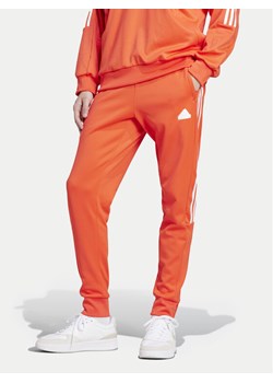 adidas Spodnie dresowe House of Tiro IW3581 Pomarańczowy Regular Fit ze sklepu MODIVO w kategorii Spodnie męskie - zdjęcie 182688323