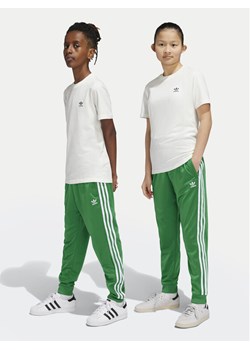 adidas Spodnie dresowe adicolor SST IY7461 Zielony Regular Fit ze sklepu MODIVO w kategorii Spodnie chłopięce - zdjęcie 182692383