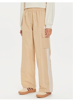 adidas Spodnie dresowe adicolor 3-Stripes IZ0717 Beżowy Loose Fit ze sklepu MODIVO w kategorii Spodnie damskie - zdjęcie 182692814