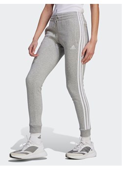 adidas Spodnie dresowe Essentials 3-Stripes IL3282 Szary Slim Fit ze sklepu MODIVO w kategorii Spodnie damskie - zdjęcie 182692893