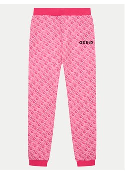 Guess Spodnie dresowe J4YQ11 KA6R4 Różowy Relaxed Fit ze sklepu MODIVO w kategorii Spodnie dziewczęce - zdjęcie 182698790