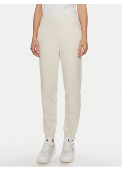 Calvin Klein Spodnie dresowe Micro Logo K20K206632 Écru Regular Fit ze sklepu MODIVO w kategorii Spodnie damskie - zdjęcie 182698933