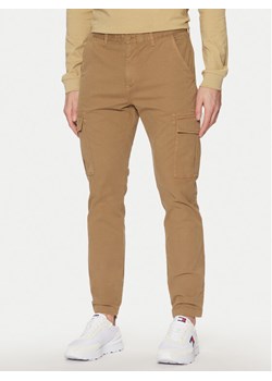Tommy Jeans Spodnie materiałowe Austin DM0DM20281 Beżowy Regular Fit ze sklepu MODIVO w kategorii Spodnie męskie - zdjęcie 182700594