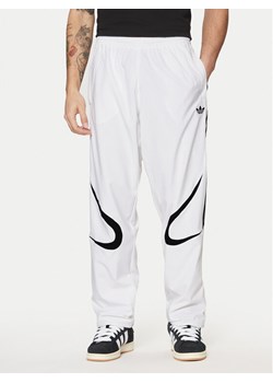 adidas Spodnie dresowe adicolor Teamgeist JP1119 Biały Regular Fit ze sklepu MODIVO w kategorii Spodnie męskie - zdjęcie 182701704