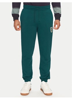 Puma Spodnie dresowe Sports Legacy Graphic 629631 Zielony Regular Fit ze sklepu MODIVO w kategorii Spodnie męskie - zdjęcie 182704030