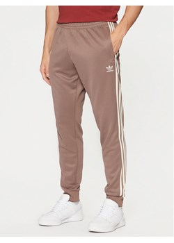 adidas Spodnie dresowe adicolor Classics SST JP2518 Beżowy Slim Fit ze sklepu MODIVO w kategorii Spodnie męskie - zdjęcie 182707261