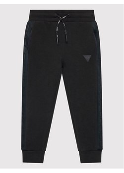 Guess Spodnie dresowe J2YQ24 FL03S Czarny Regular Fit ze sklepu MODIVO w kategorii Spodnie chłopięce - zdjęcie 182709324