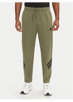adidas Spodnie dresowe Future Icons 3-Stripes JD4891 Zielony Loose Fit ze sklepu MODIVO w kategorii Spodnie męskie - zdjęcie 182721402