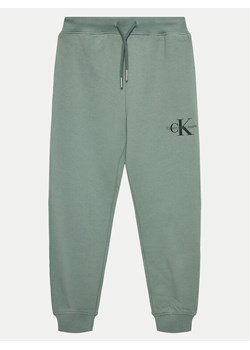 Calvin Klein Jeans Spodnie dresowe Monogram Logo IU0IU00285 D Zielony Regular Fit ze sklepu MODIVO w kategorii Spodnie chłopięce - zdjęcie 182722383