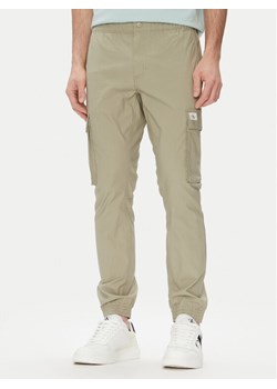 Calvin Klein Jeans Joggery J30J327614 Zielony Slim Fit ze sklepu MODIVO w kategorii Spodnie męskie - zdjęcie 182726861