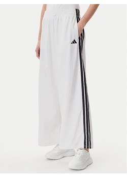 adidas Spodnie dresowe Essentials 3-Stripes JE1307 Biały Loose Fit ze sklepu MODIVO w kategorii Spodnie damskie - zdjęcie 182732481