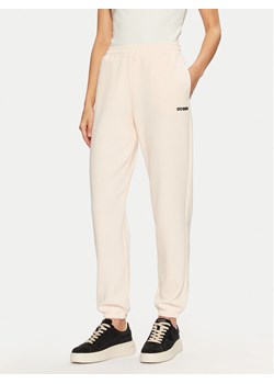 Guess Spodnie dresowe V5RB02 KCLD1 Écru Regular Fit ze sklepu MODIVO w kategorii Spodnie damskie - zdjęcie 182741024