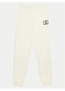 Tommy Hilfiger Spodnie dresowe Monotype KG0KG08107 Écru Regular Fit ze sklepu MODIVO w kategorii Spodnie dziewczęce - zdjęcie 182744283