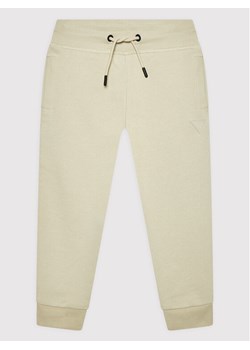 Guess Spodnie dresowe L2YQ46 KAIJ1 Beżowy Regular Fit ze sklepu MODIVO w kategorii Spodnie chłopięce - zdjęcie 182744780