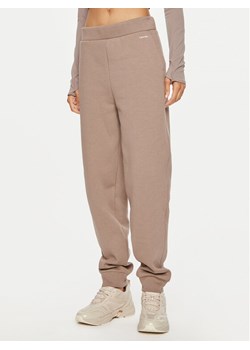 Calvin Klein Spodnie dresowe Nano Logo K20K208330 Beżowy Regular Fit ze sklepu MODIVO w kategorii Spodnie damskie - zdjęcie 182750250