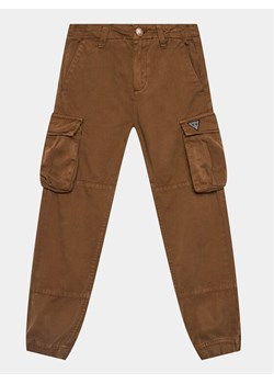Guess Spodnie materiałowe L3BB02 WE1L0 Brązowy Regular Fit ze sklepu MODIVO w kategorii Spodnie chłopięce - zdjęcie 182753313