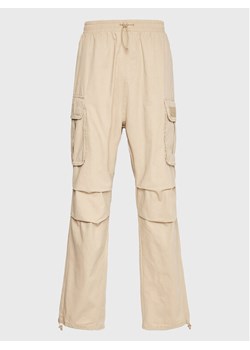Karl Kani Spodnie materiałowe Rubber Signature 6002506 Beżowy Relaxed Fit ze sklepu MODIVO w kategorii Spodnie męskie - zdjęcie 182759790