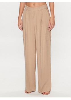 DKNY Spodnie materiałowe P3BKTR20 Beżowy Relaxed Fit ze sklepu MODIVO w kategorii Spodnie damskie - zdjęcie 182764502