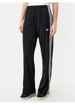 adidas Spodnie dresowe adicolor Classic Firebird JC8245 Czarny Loose Fit ze sklepu MODIVO w kategorii Spodnie damskie - zdjęcie 183593313
