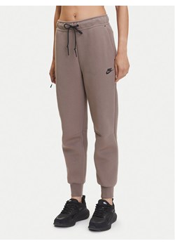 Nike Spodnie dresowe Tech Fleece HV6779 Brązowy Regular Fit ze sklepu MODIVO w kategorii Spodnie damskie - zdjęcie 183595743