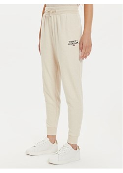 Tommy Hilfiger Spodnie dresowe UW0UW04522 Beżowy Regular Fit ze sklepu MODIVO w kategorii Spodnie damskie - zdjęcie 183652663